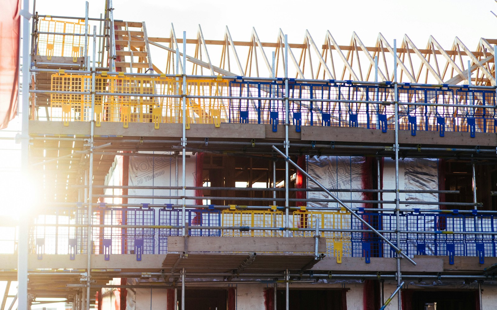 Active commercial construction project with scaffolding and staged building materials.